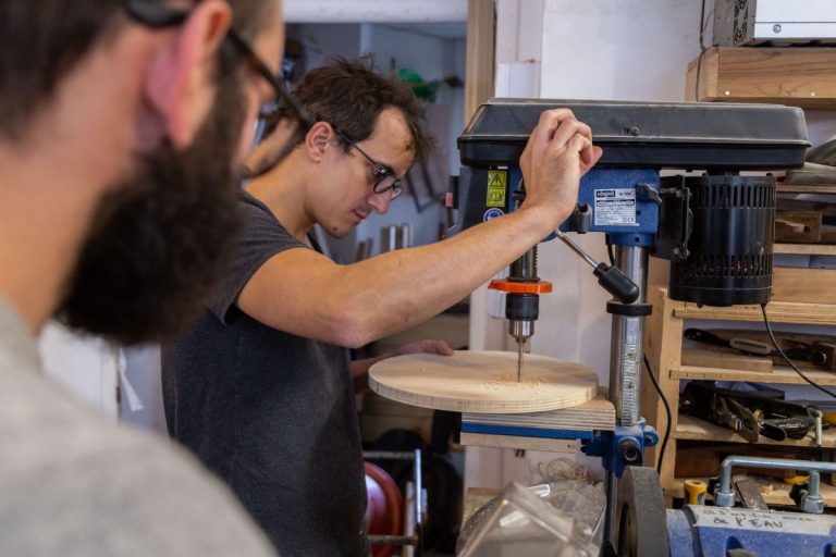 Un homme apprends à bricoler dans un atelier