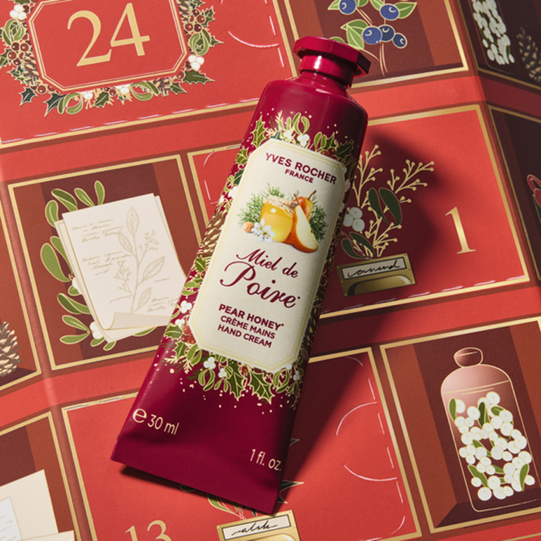 Crème mains Miel de Poire Yves Rocher en tube rouge de 30 ml, posée sur un calendrier de l’Avent illustré