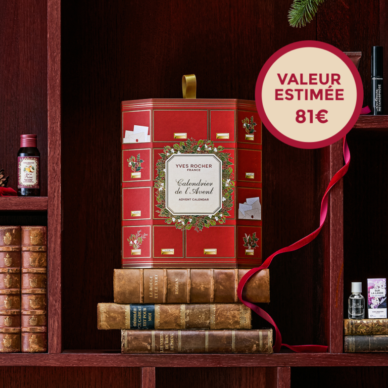 Le calendrier de l’Avent Yves Rocher 2026, une boîte rouge à tiroirs ornée d’une couronne de Noël, posée sur des livres anciens, avec la mention valeur estimée 81 €