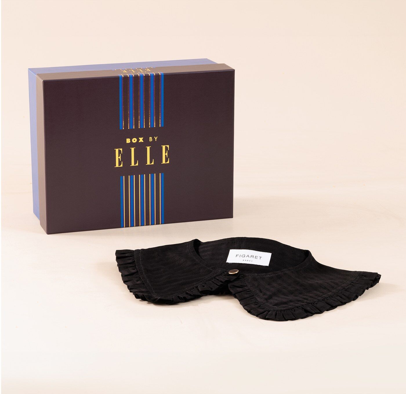 Le coffret Box by ELLE à rayures bleu et or posé près du col Claudine noir Figaret
