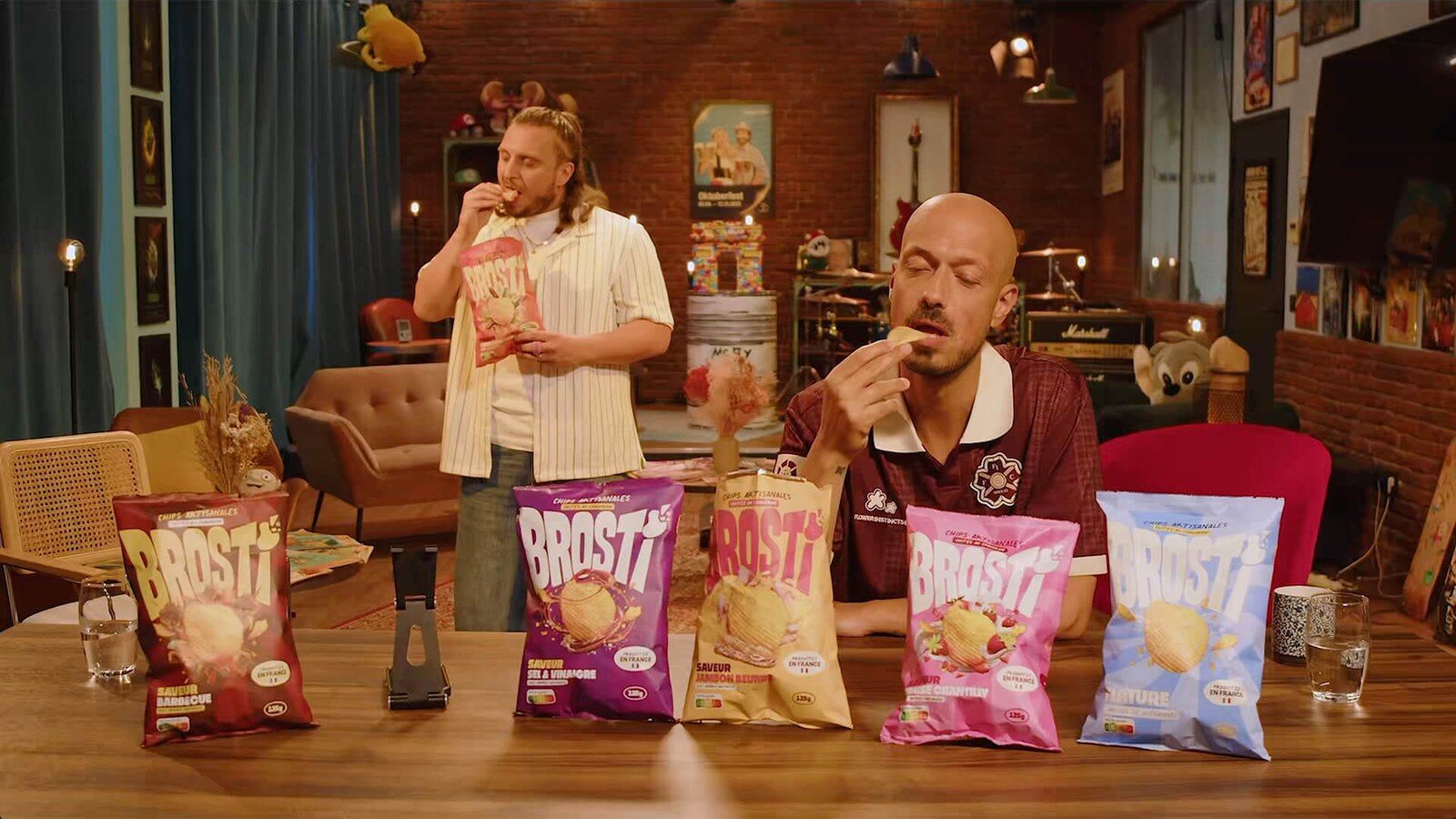 McFly et Carlito assis à une table, goûtant les chips Brosti devant cinq paquets de différents parfums