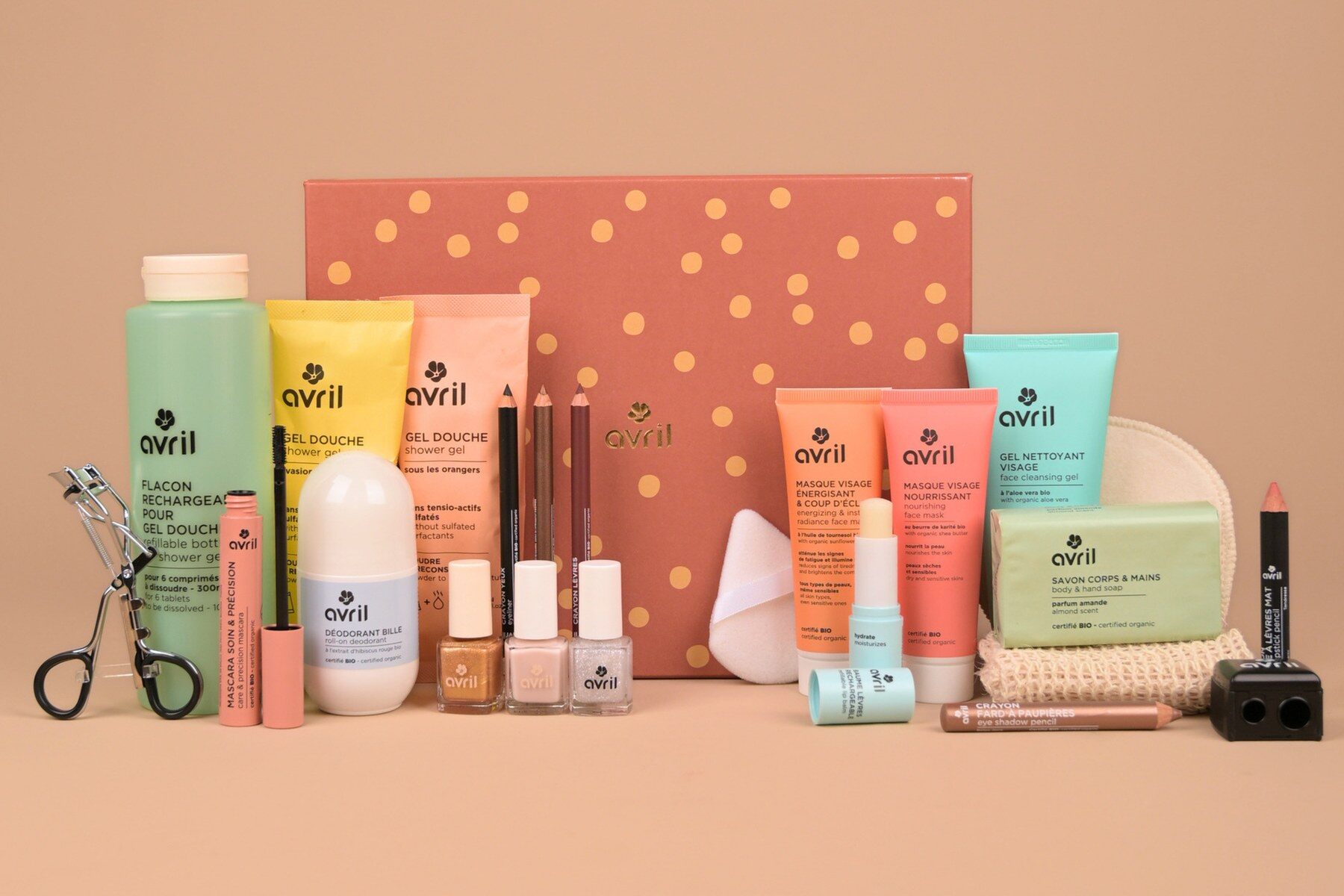 Les 24 produits du calendrier de l’Avent Avril 2026 alignés devant le coffret rose à pois dorés