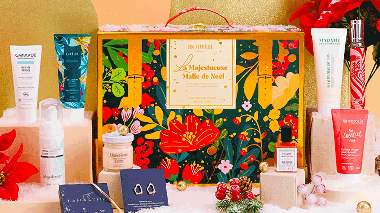 Le calendrier de l'Avent Biotyfull Box 2026, La Majestueuse Malle de Noël, entouré d'une partie de ses produits : Gamarde, Algologie, Centifolia, Adopt Lova Lova et bijoux Lamarthe