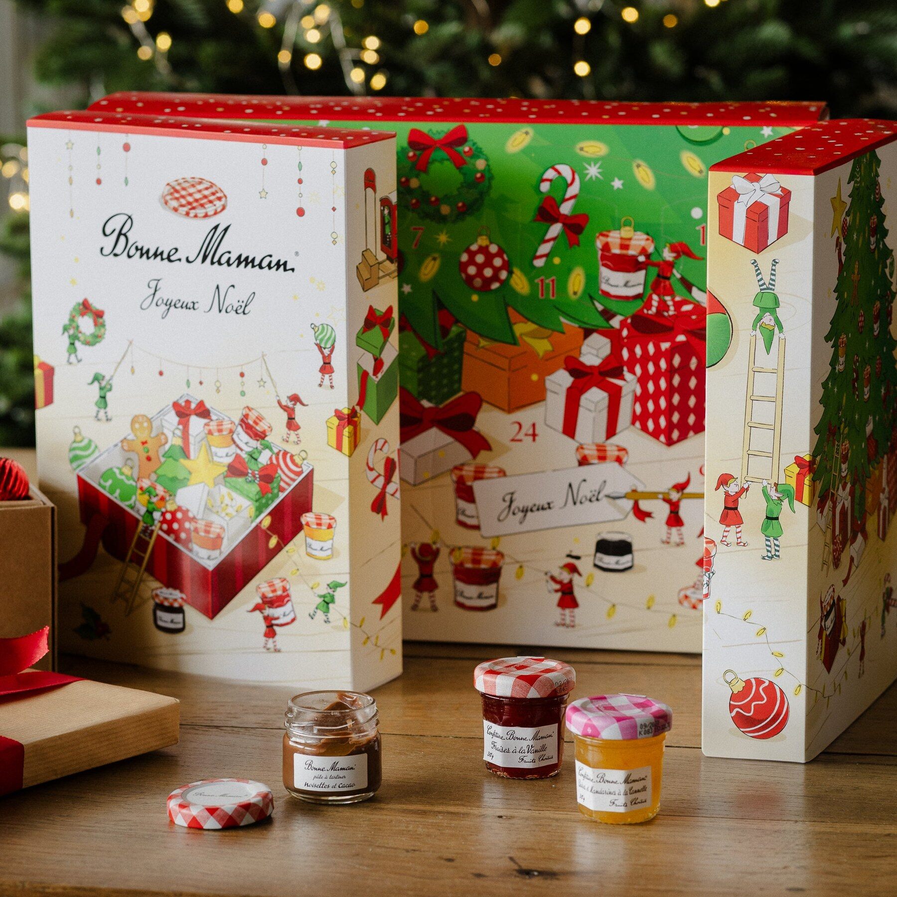 Calendrier de l’Avent Bonne Maman 2026 ouvert, avec ses petits pots de confiture, devant un sapin