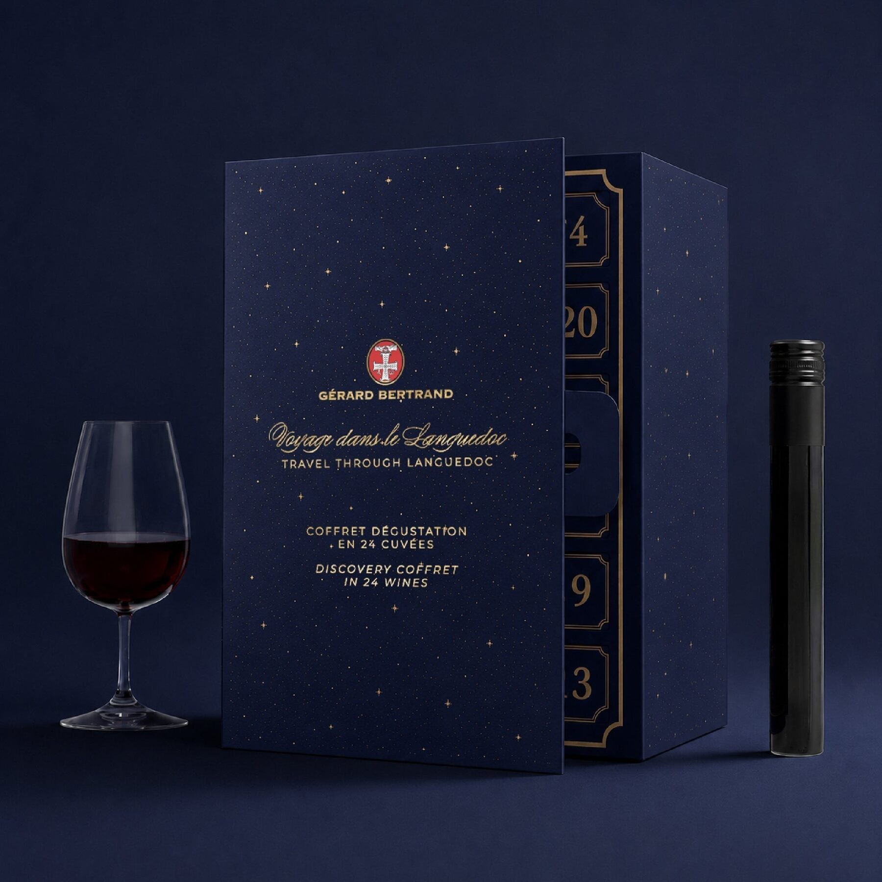 Le calendrier de l’Avent Gérard Bertrand 24 Cuvées 2026 : un coffret bleu nuit étoilé « Voyage dans le Languedoc », un verre de vin rouge et un tube de dégustation