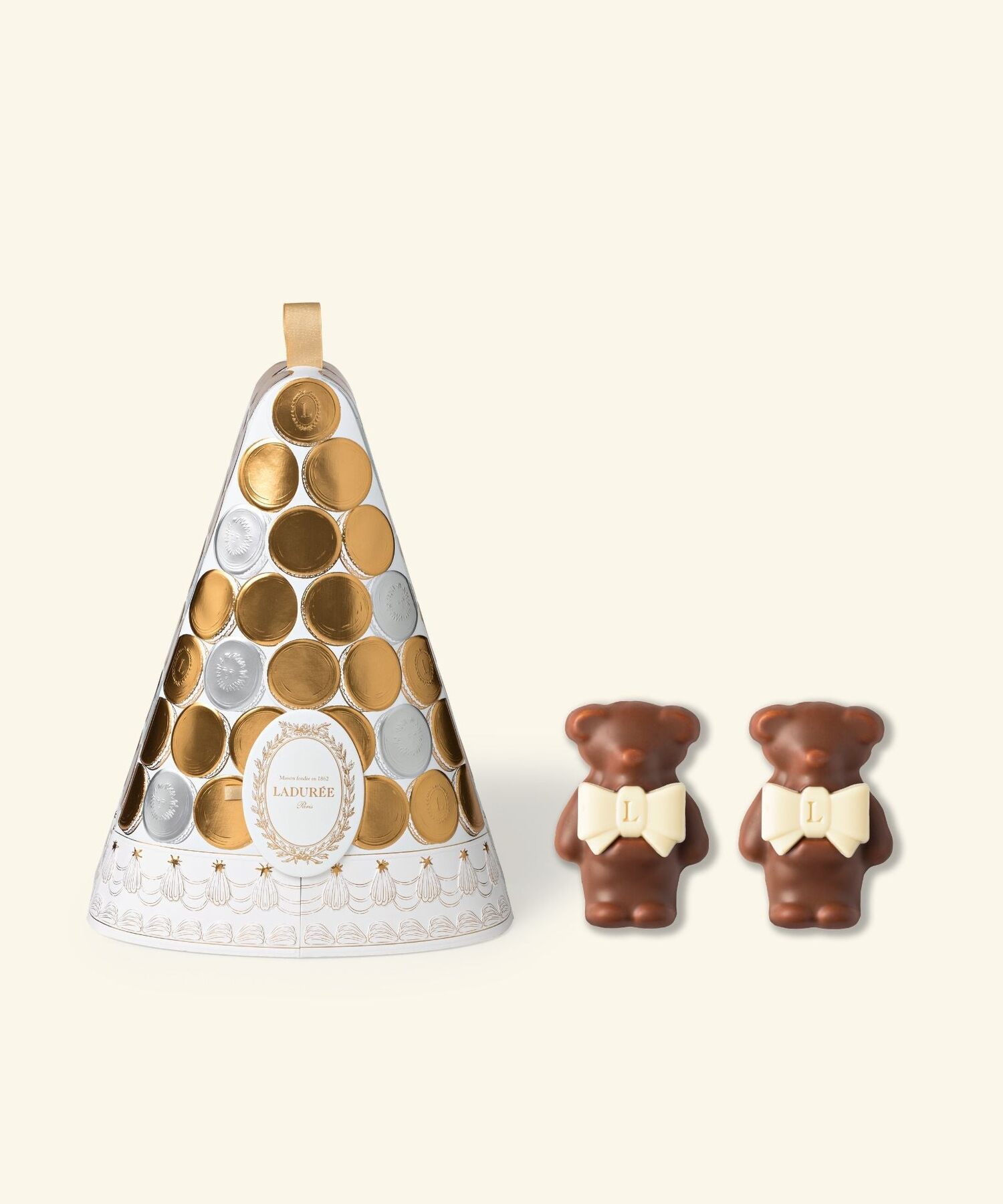 Le calendrier de l’Avent Ladurée 2026, une pyramide blanche ornée de pastilles dorées, à côté de deux oursons en chocolat