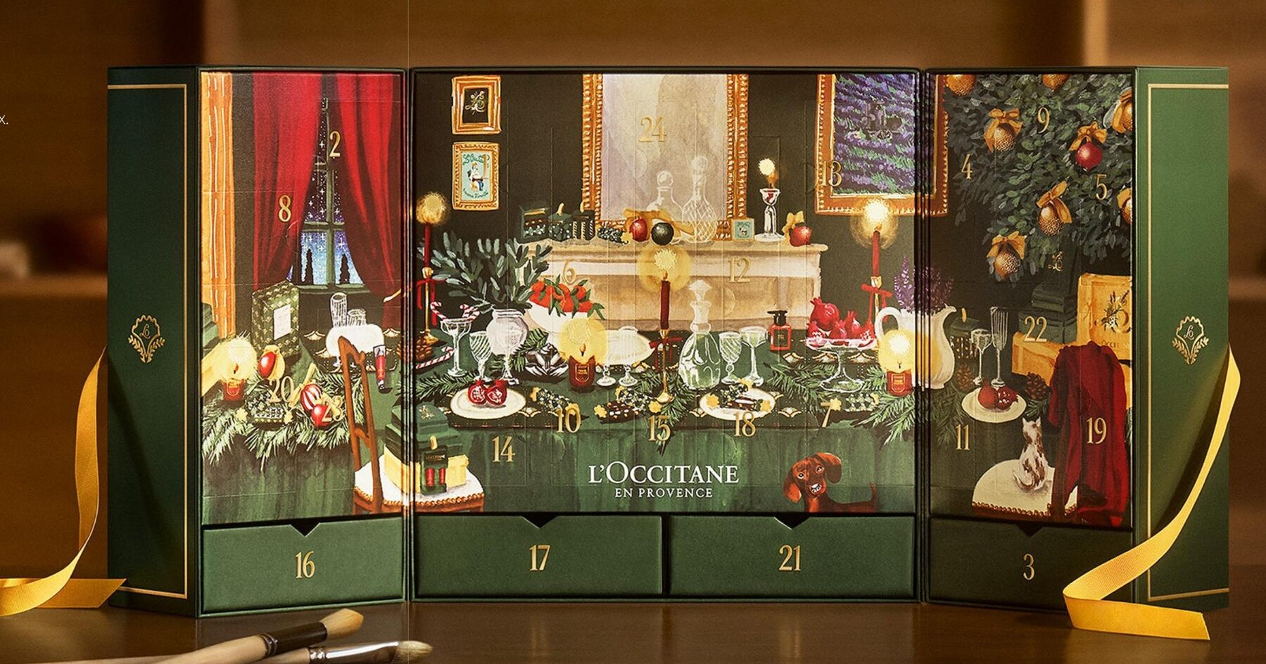 Un calendrier de l’Avent L’Occitane 2026 ouvert en triptyque, avec son décor peint de salon provençal, sa table de fête et ses tiroirs numérotés