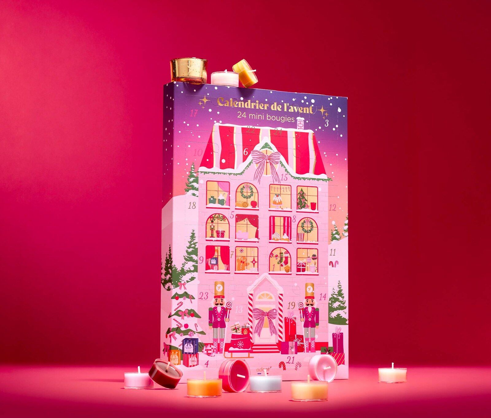Le calendrier de l’Avent Adopt La Maison de Noël 2026, illustré d’une maison de Noël rose, entouré de mini-bougies parfumées