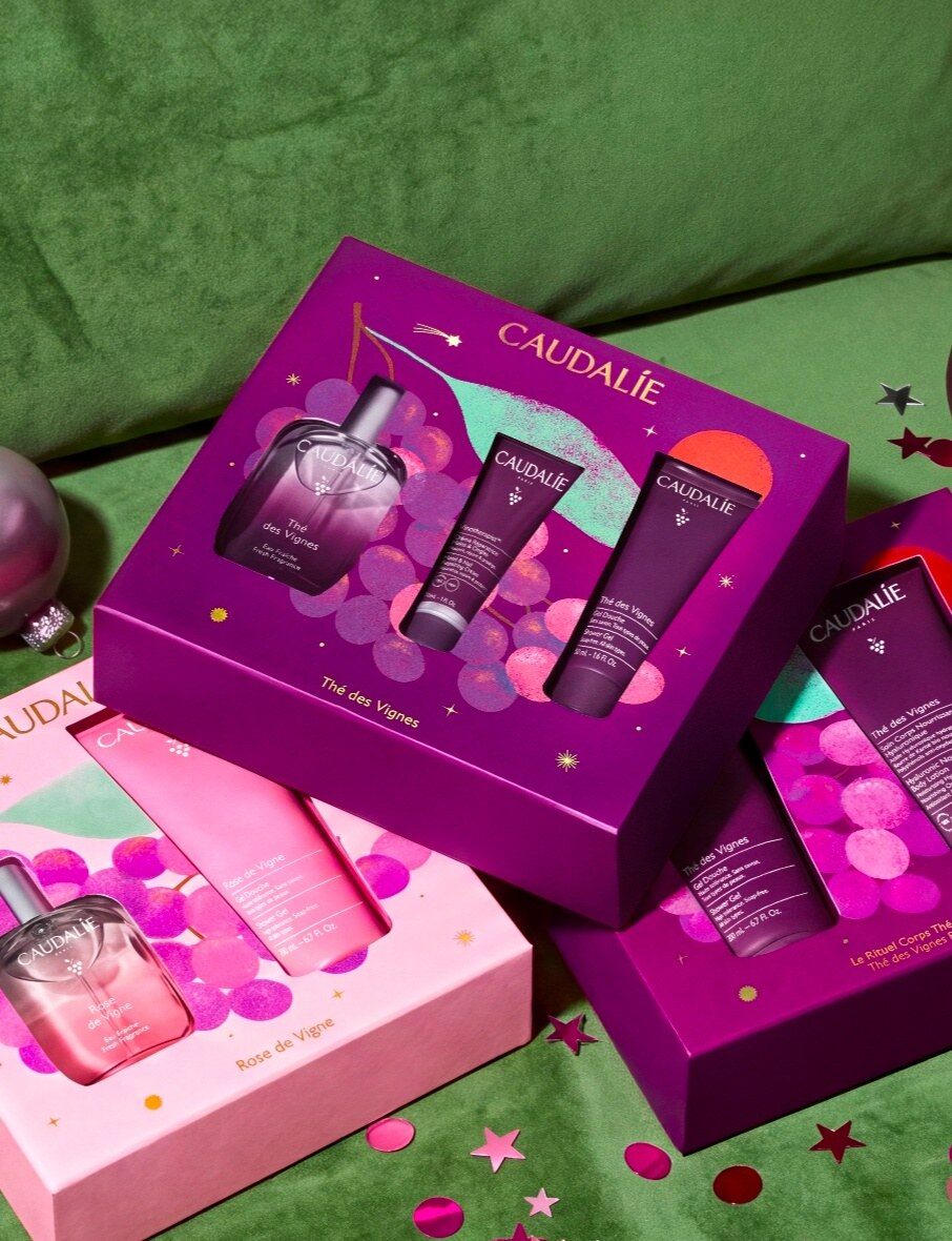 Coffrets de Noël Caudalie Thé des Vignes et Rose de Vigne posés sur un velours vert parsemé d’étoiles