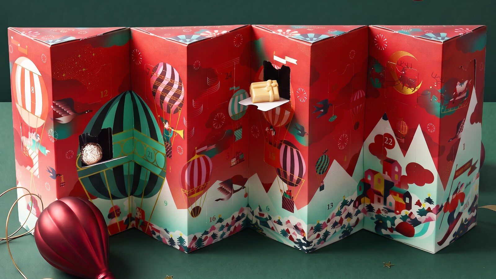 Calendrier de l’Avent De Neuville 2026 déplié en accordéon, deux cases ouvertes sur des chocolats, décor de montgolfières
