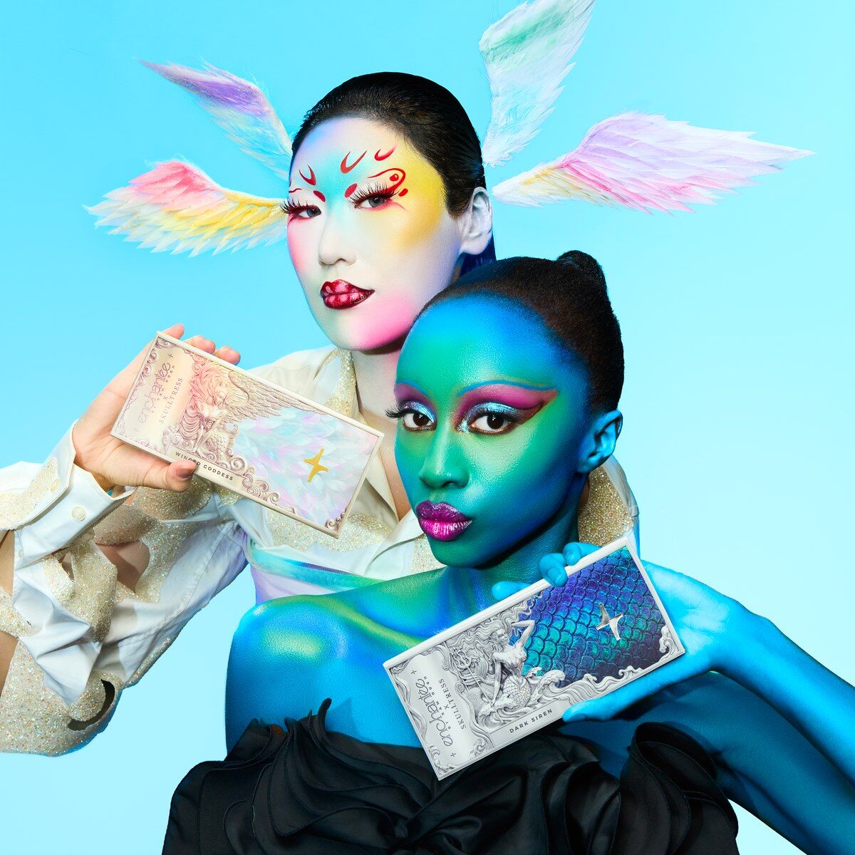Deux mannequins maquillées, l’une en bleu, l’autre avec des ailes irisées, tenant chacune une palette Enchantée x Skulltress