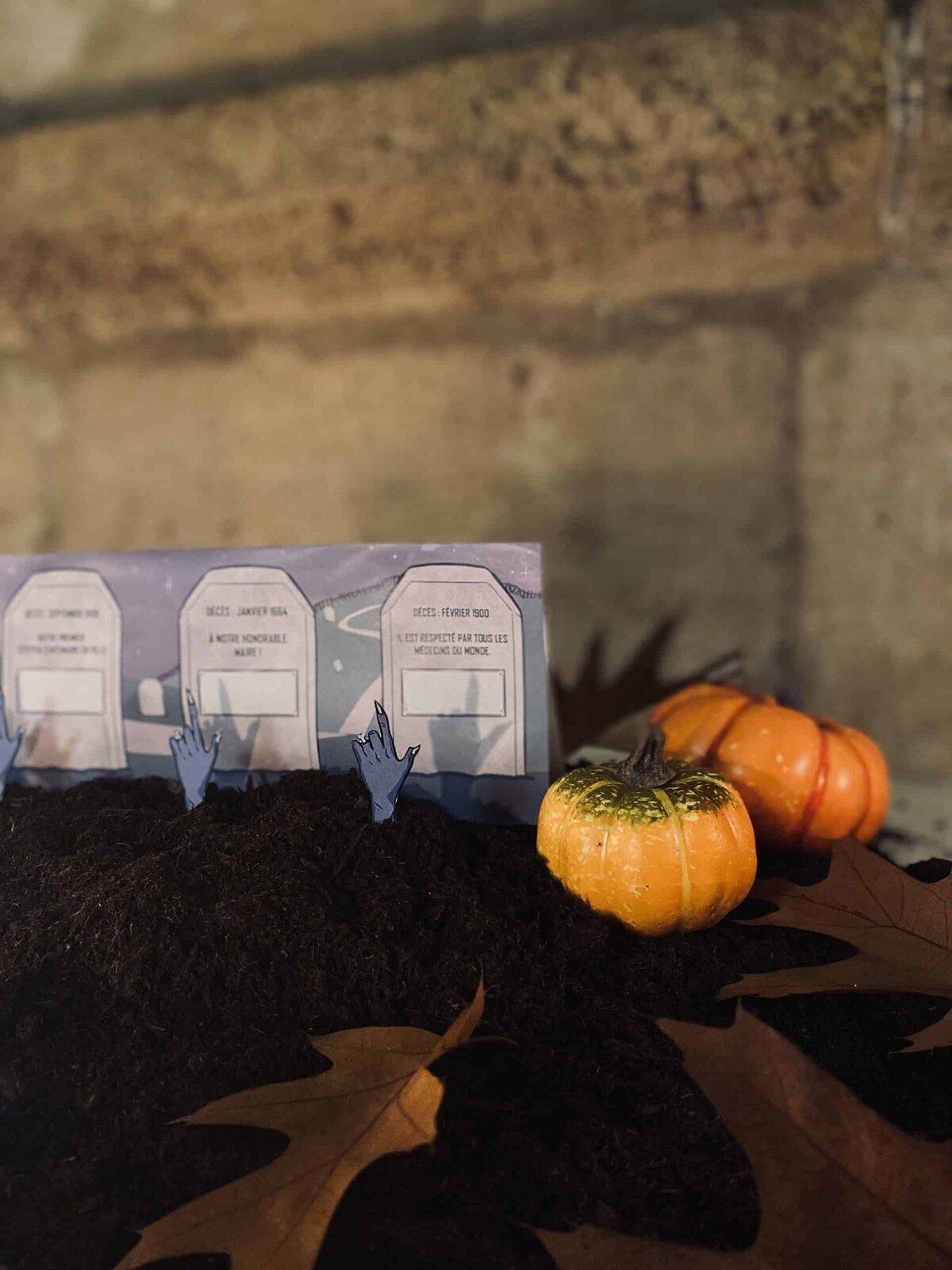 Décor de cimetière imprimé avec pierres tombales et citrouilles pour l’escape game Le mystère des citrouilles