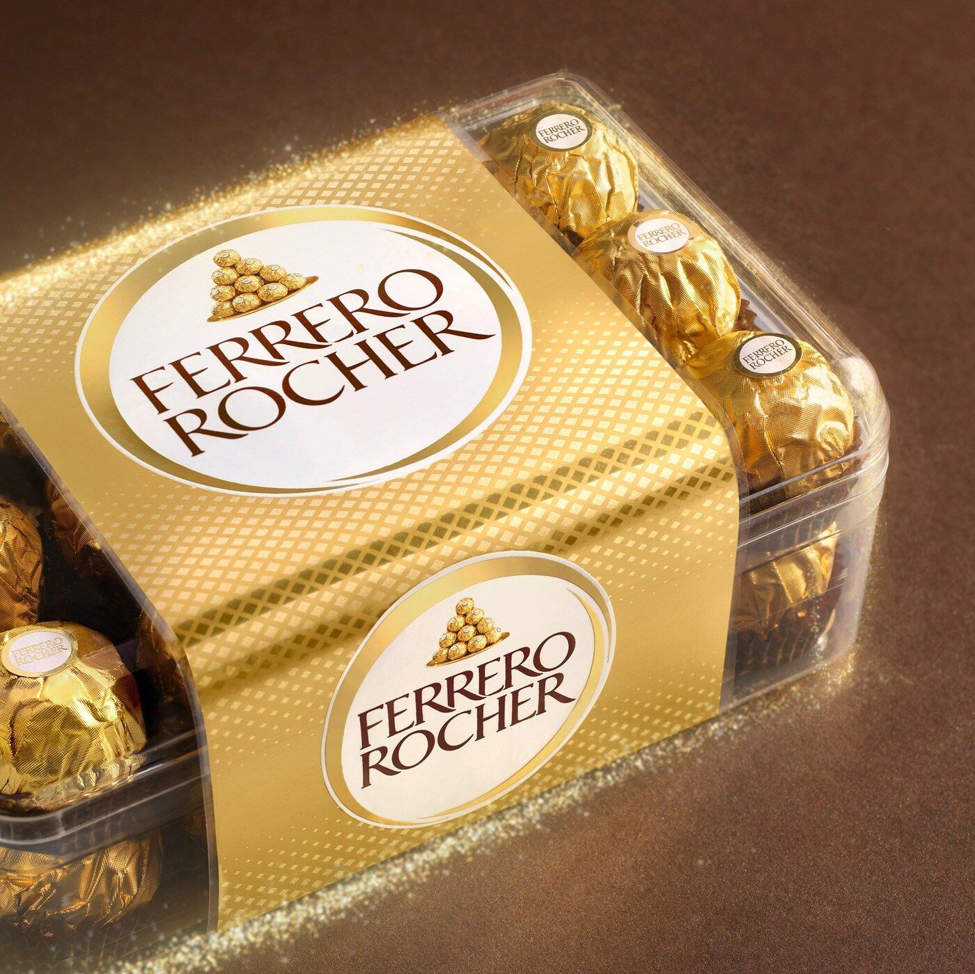 Une boîte de 16 Ferrero Rocher sur un fond brun pailleté d’or