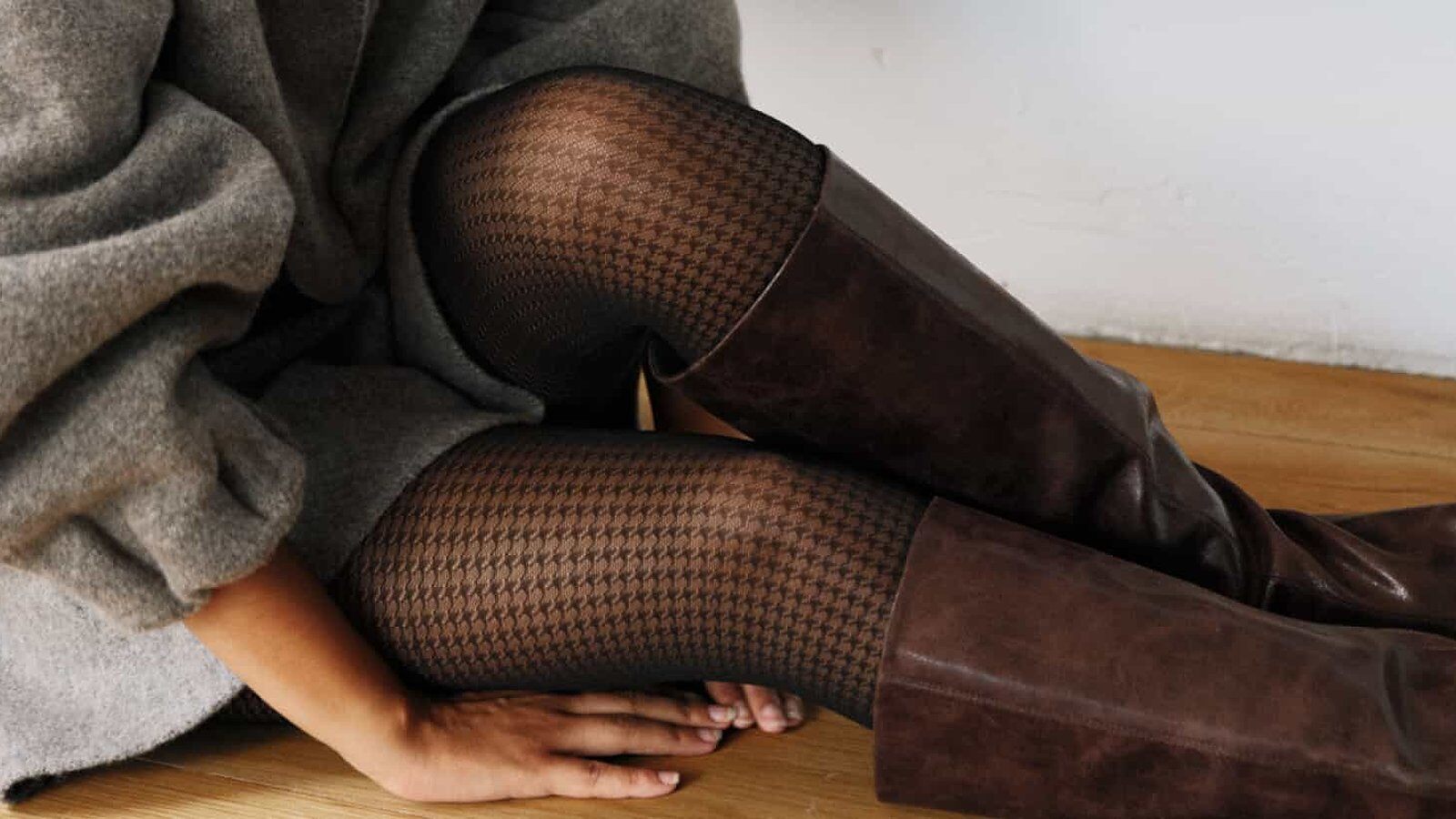 Jambes en collant pied-de-poule de la Gambettes Box d’octobre 2026, portées avec des bottes en cuir marron et un pull gris