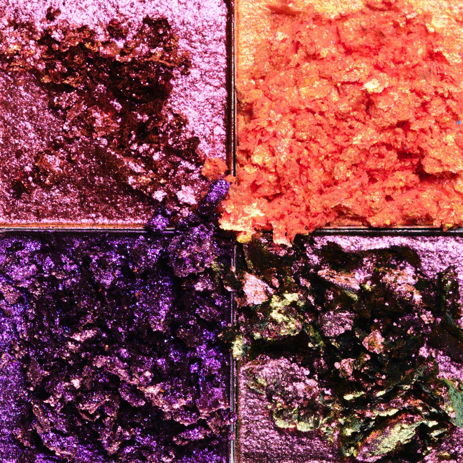 Gros plan sur quatre fards pailletés violets, orange et multichromes de la palette Hardwear