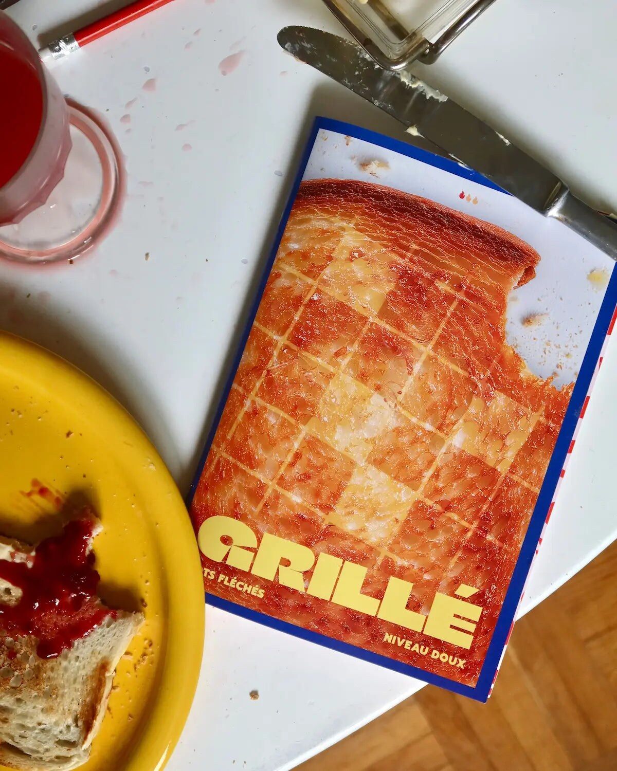Cahier de mots fléchés Grillé niveau DOUX posé sur une table de petit déjeuner