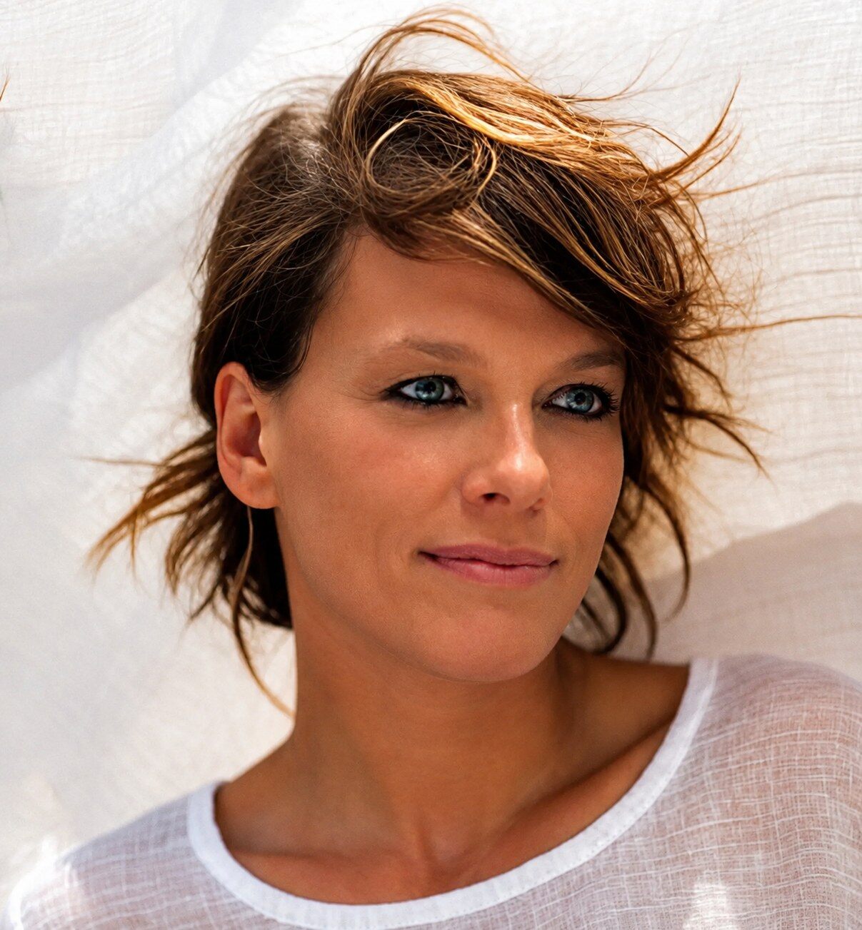 Portrait d’Anne Le Nen en t-shirt blanc, les cheveux au vent