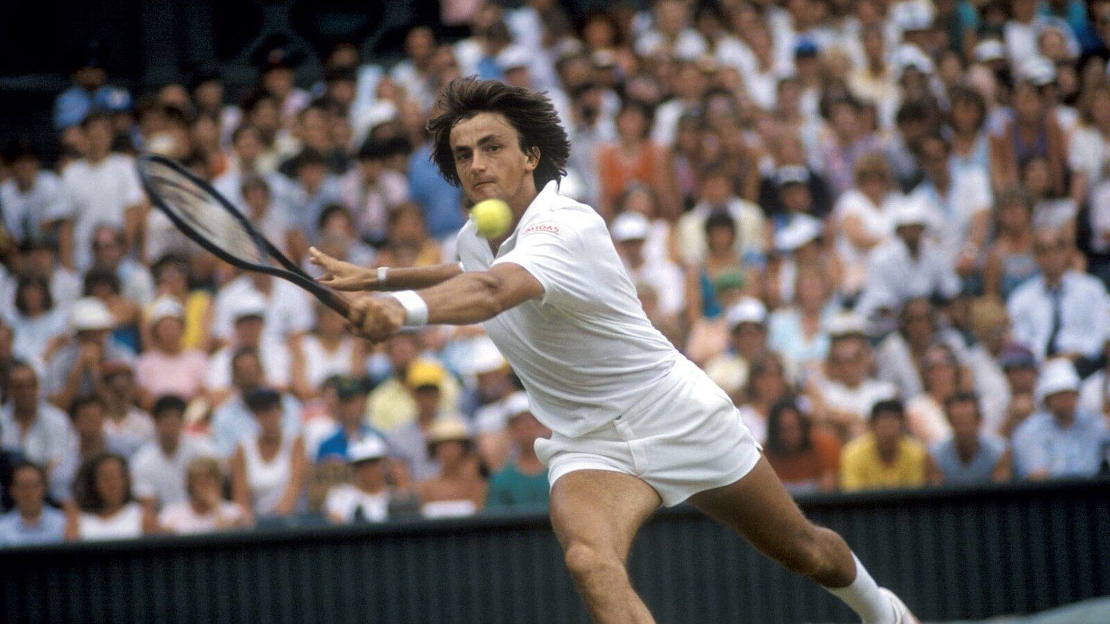 Henri Leconte en tenue blanche frappe un revers devant des tribunes pleines, photo d’archive