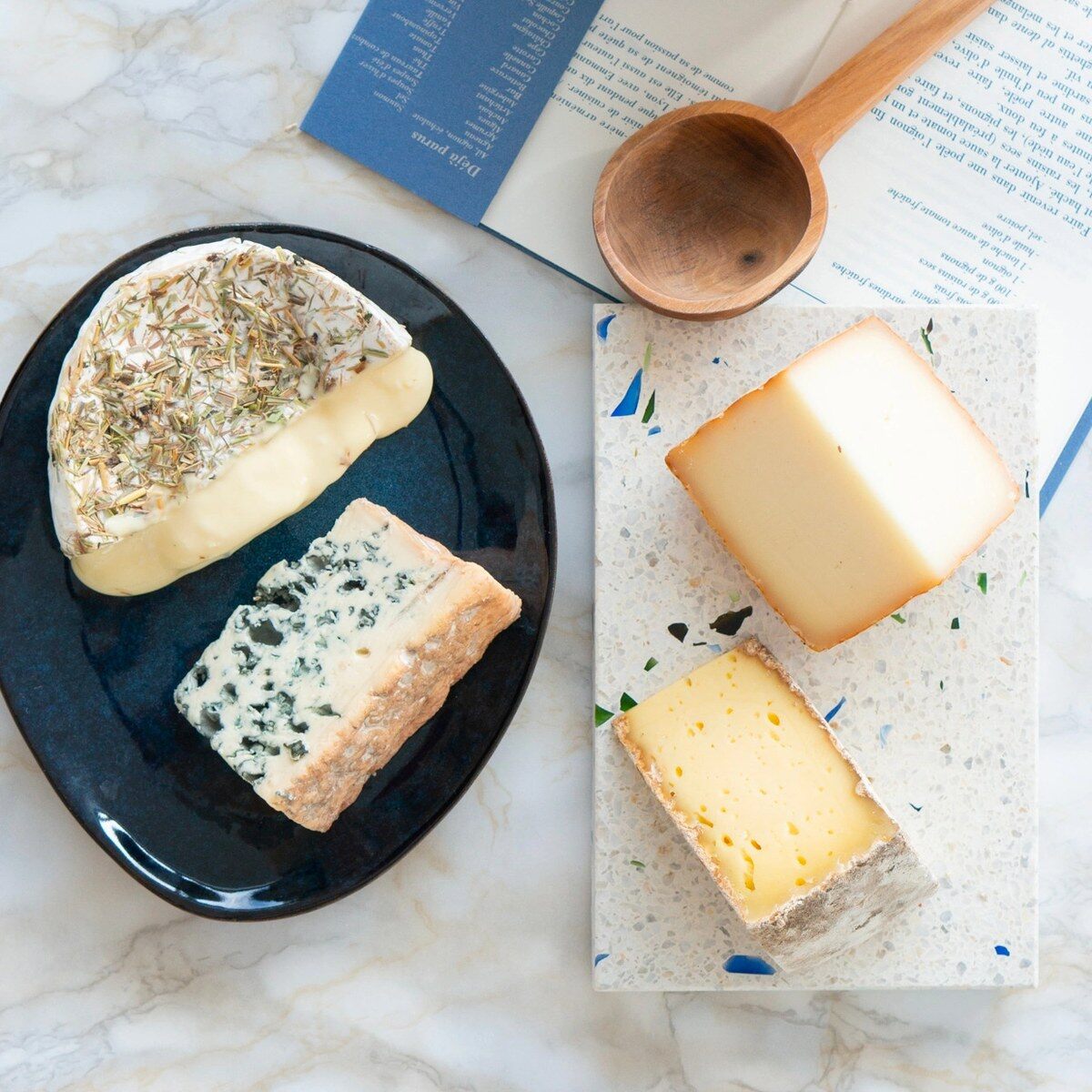 Quatre fromages de La Box Fromage dressés sur une assiette et une planche