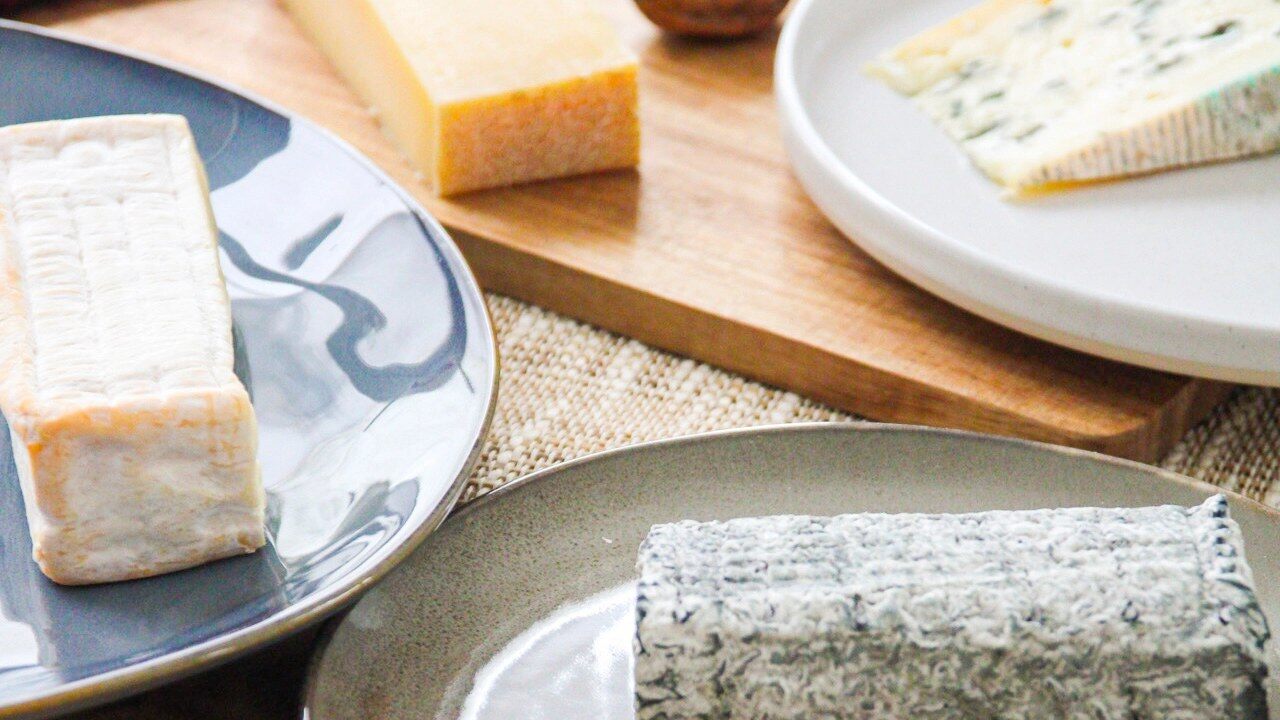 Fromages de La Box Fromage dressés sur des assiettes et une planche en bois