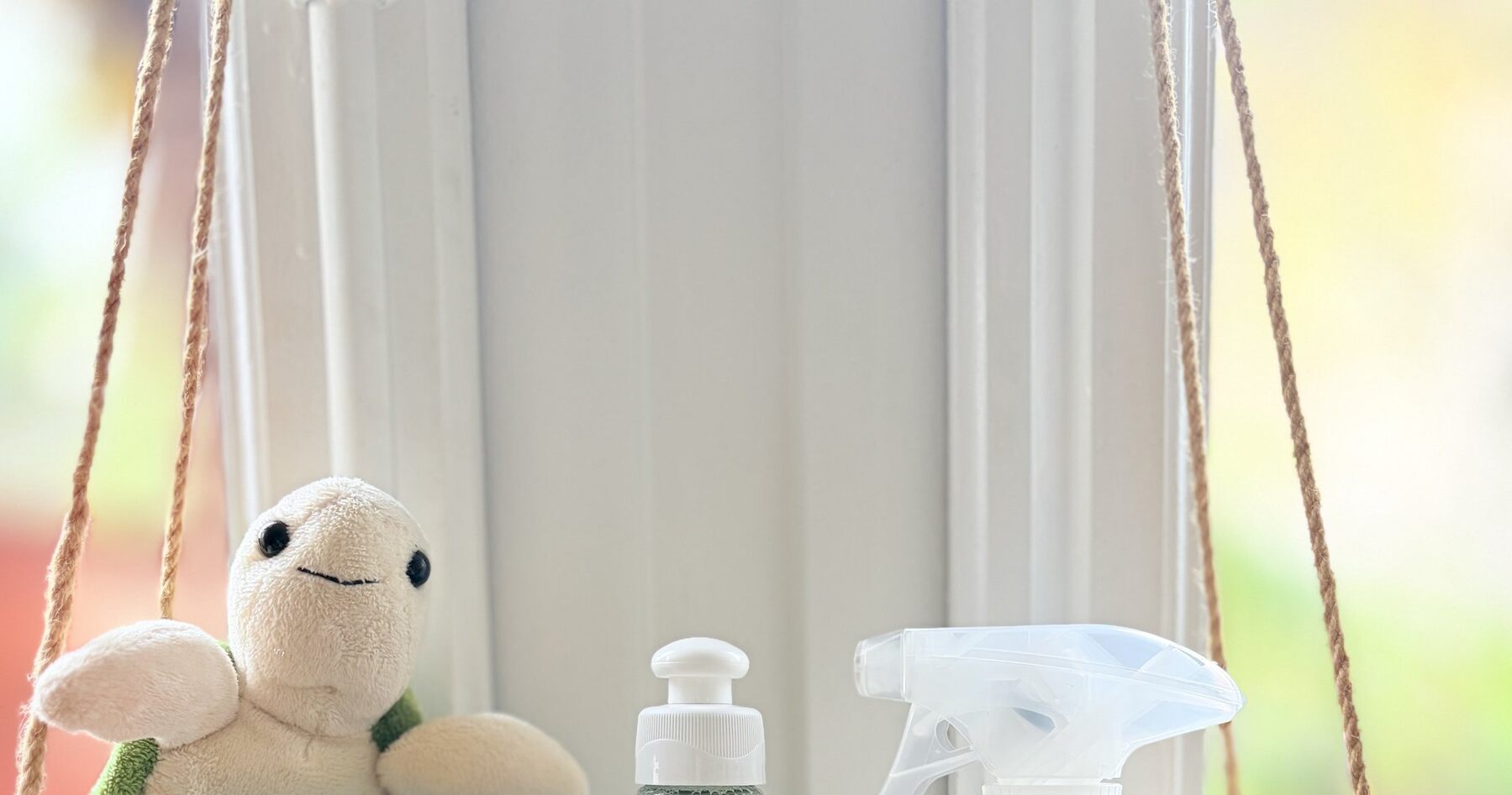 Doudou tortue et flacons sans parfum de la box bébé Lavette Box posés devant une fenêtre