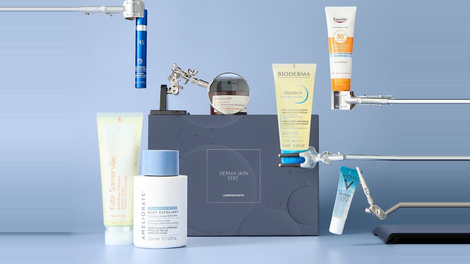 Les sept soins de l’Édition Dermatologique Lookfantastic mis en scène autour du coffret bleu sur fond bleu