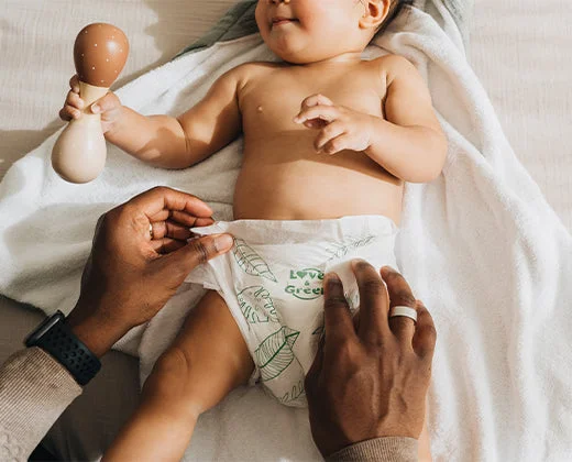 Parent changeant un bébé avec une couche Love & Green