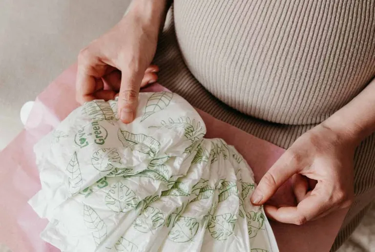 Femme enceinte tenant une pile de couches Love & Green