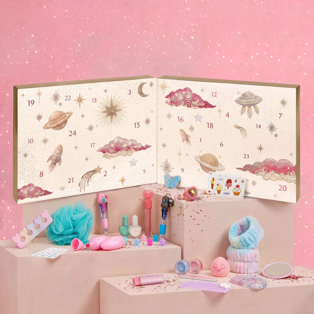Le calendrier de l’Avent enfant Marionnaud 2026 ouvert, avec ses vernis, stylos, pinces et accessoires disposés sur fond rose