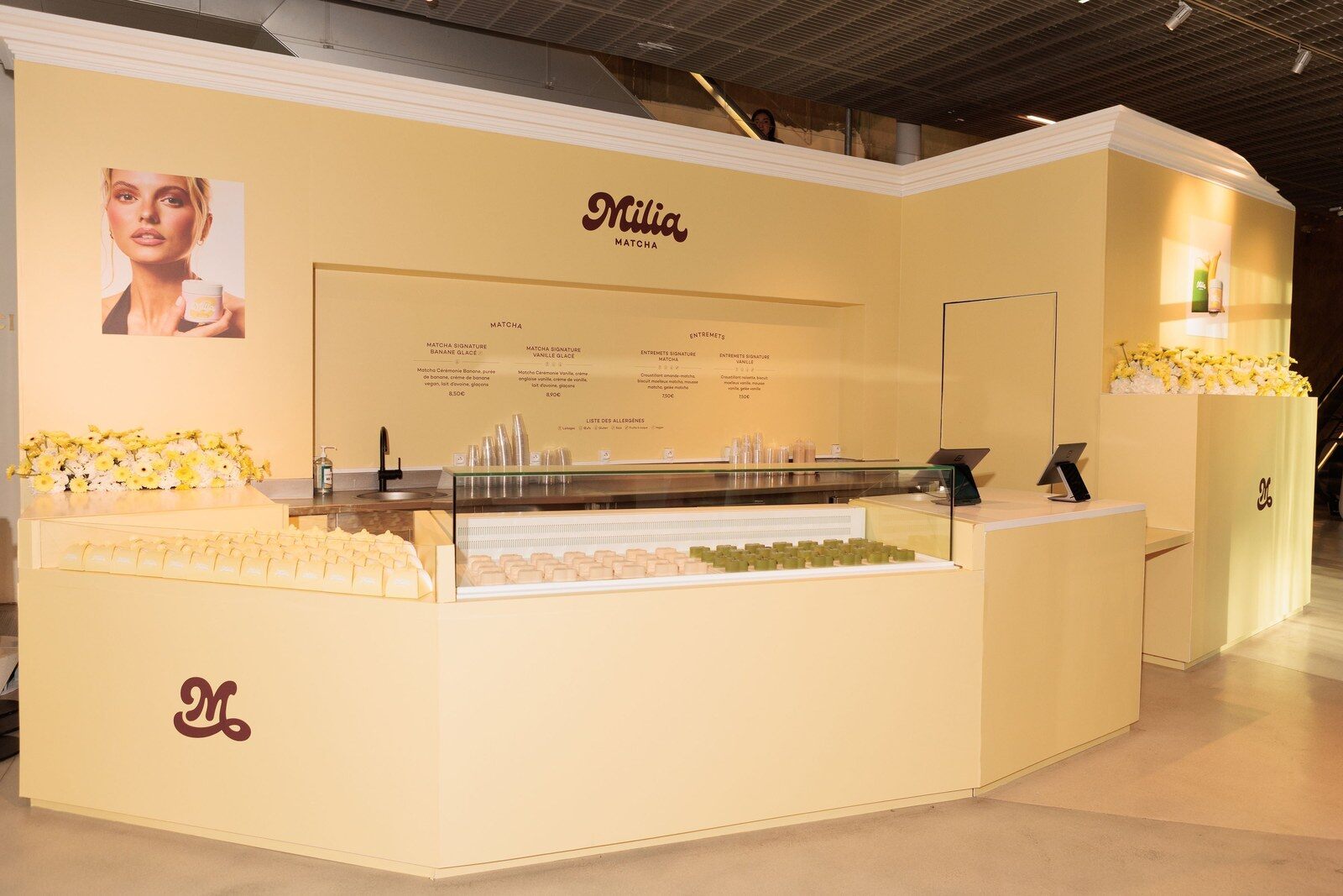 Comptoir du pop-up Milia Matcha à la Samaritaine, décor crème et portrait d’Andie Ella