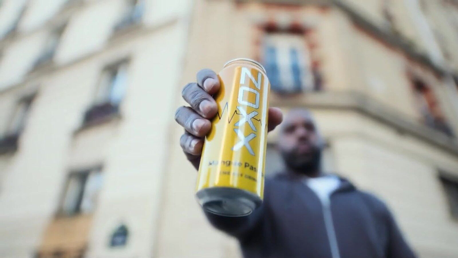 Teddy Riner tend une canette Noxx Mangue Passion dans une rue