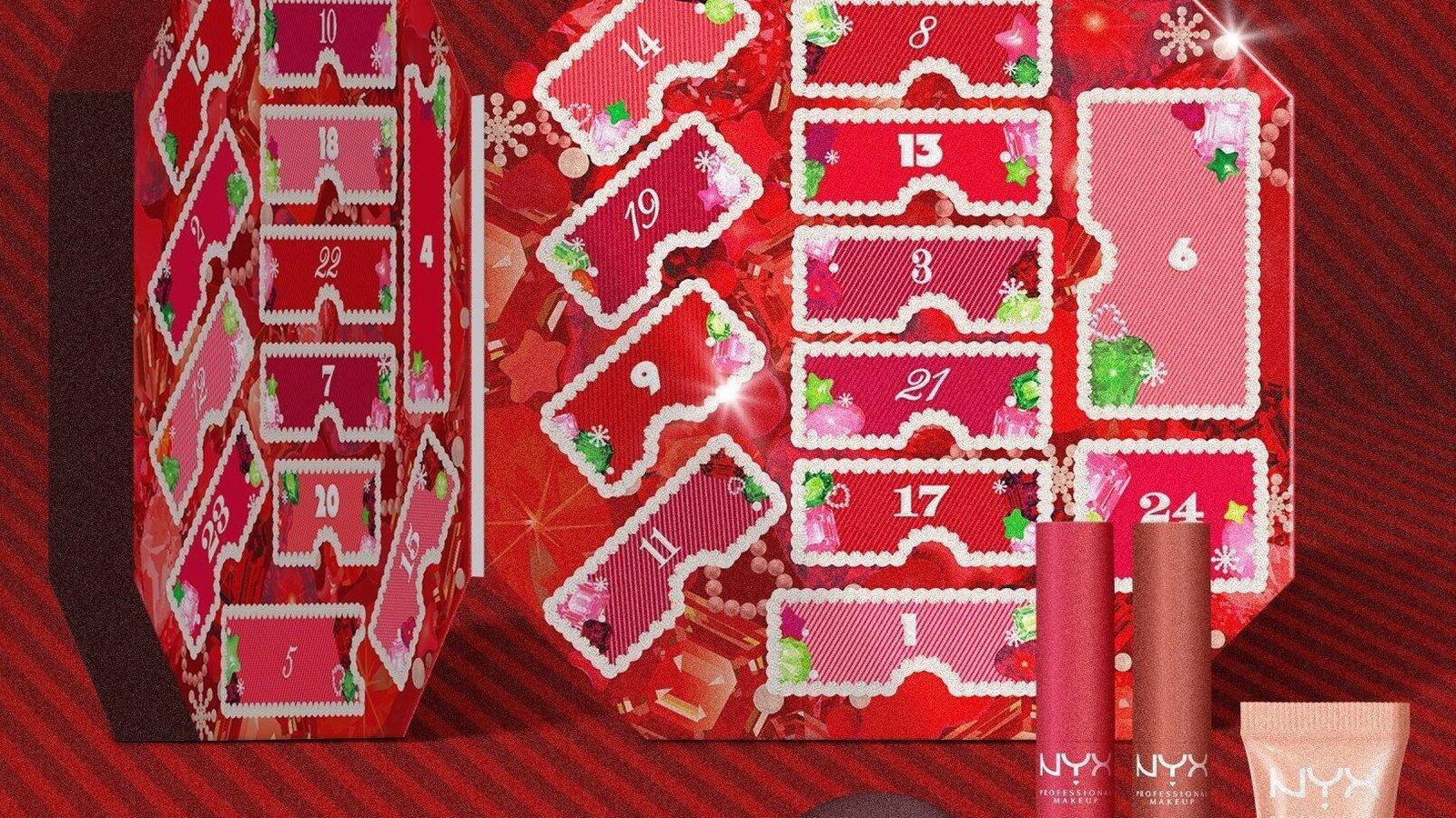 Le calendrier de l’Avent NYX Bling Box 2026 ouvert comme un livre sur un décor rouge rayé, à côté de rouges à lèvres Fat Matte