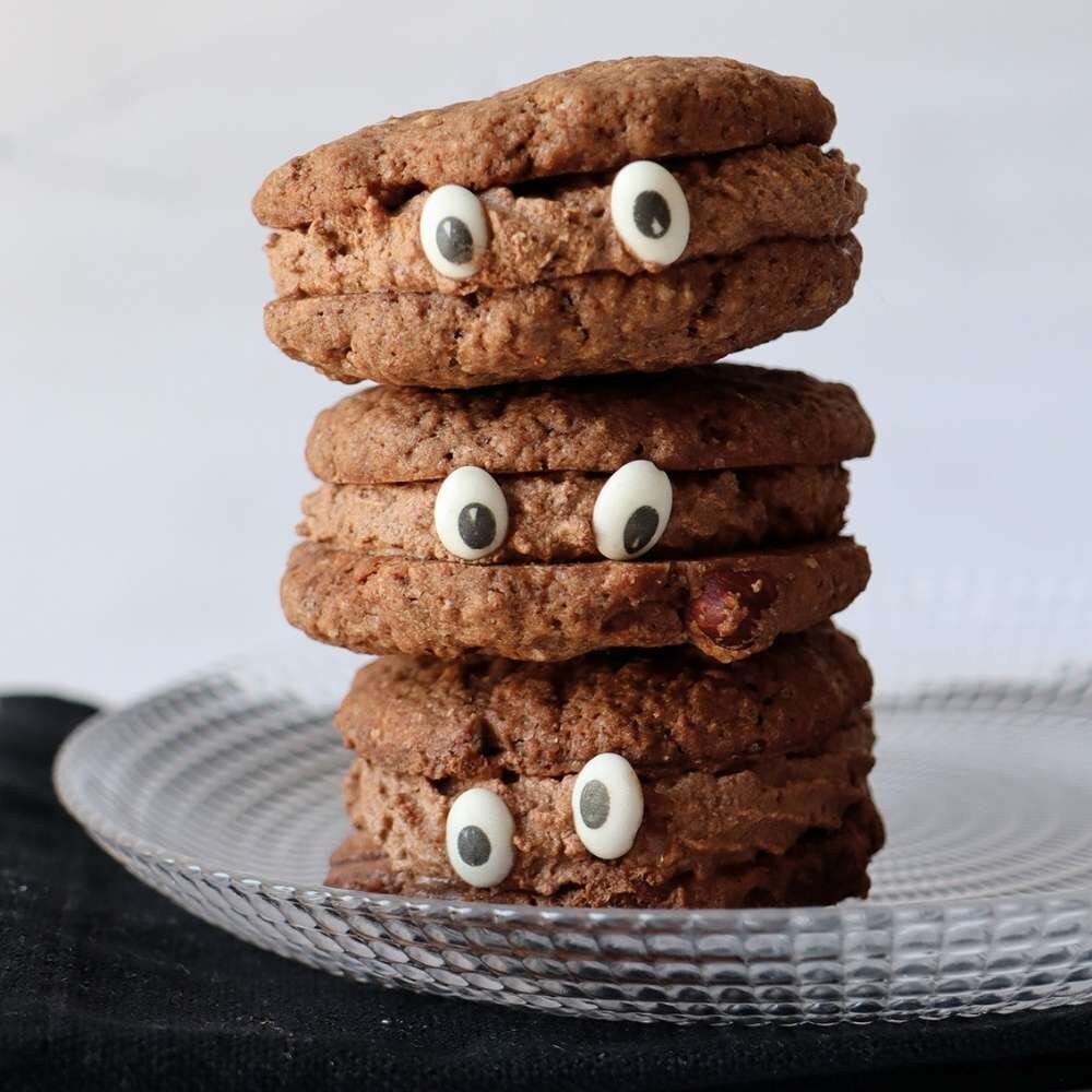 Pile de cookies au chocolat en forme de petits monstres avec des yeux en sucre