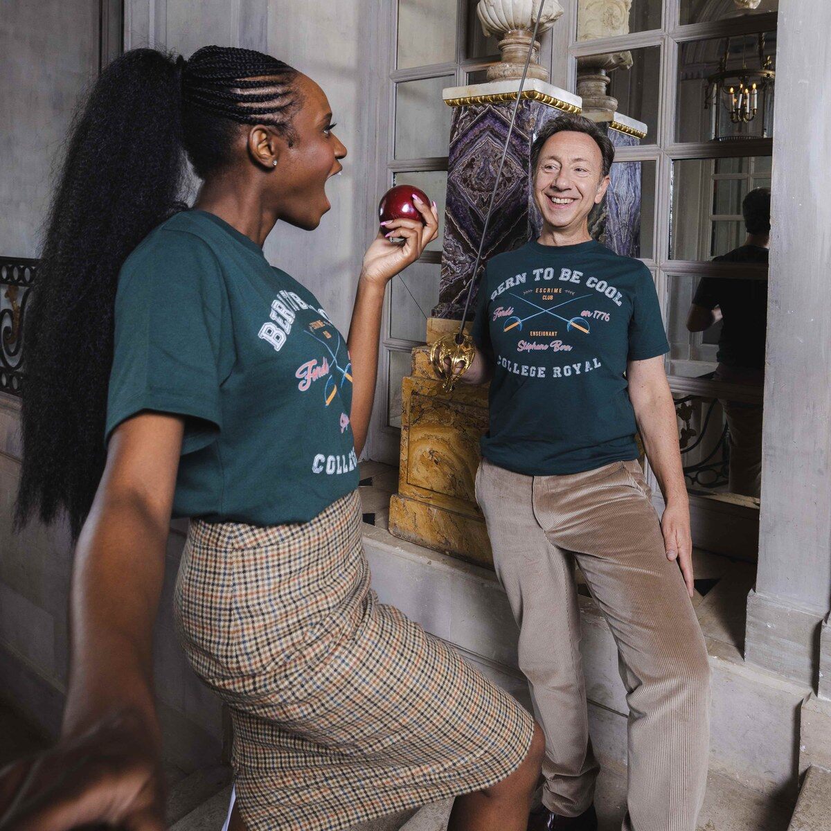 Stéphane Bern et Jeaneta Domingos en t-shirts verts « Bern to be cool » dans un décor de château