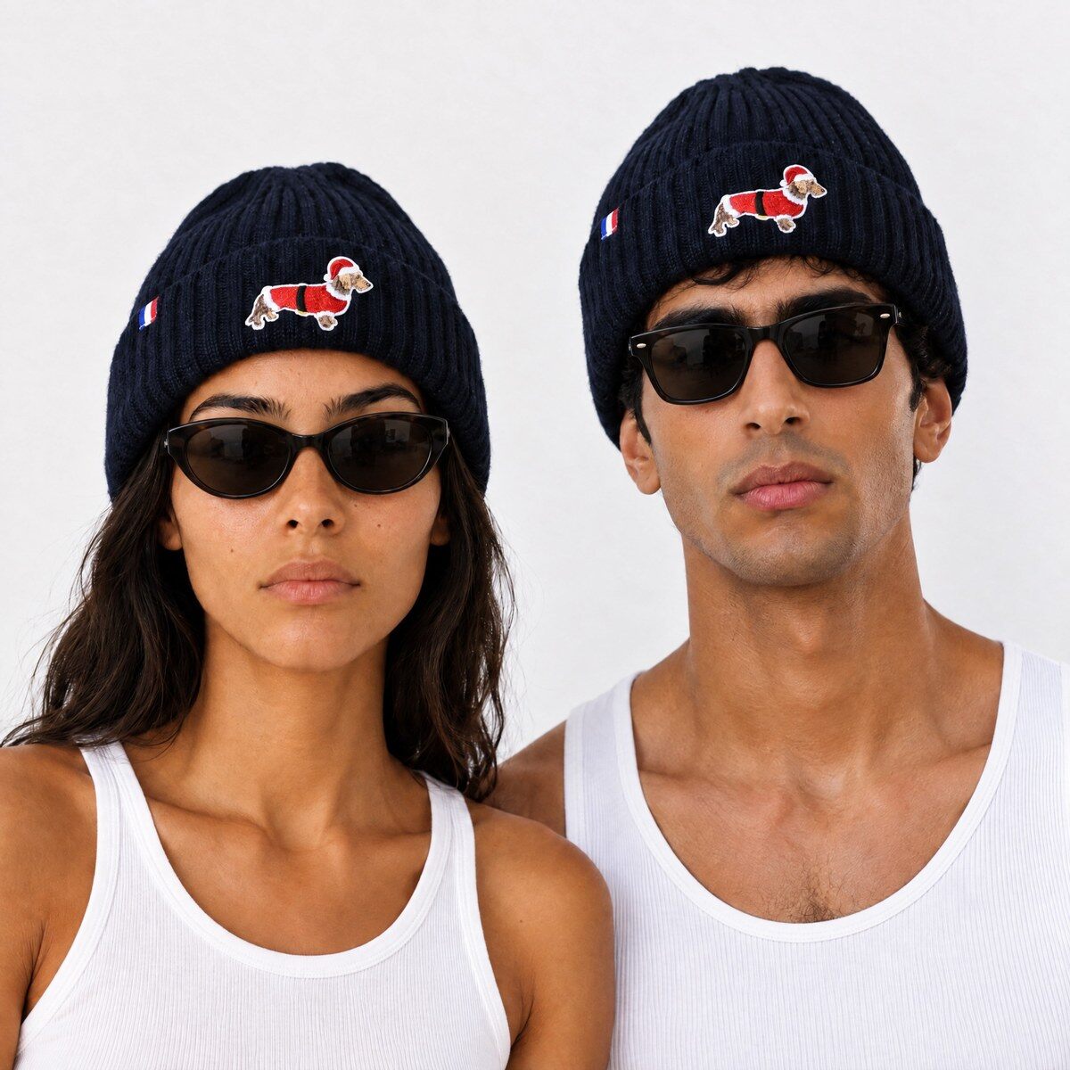 Deux mannequins portant le bonnet bleu marine Xmas Sausage avec un teckel brodé