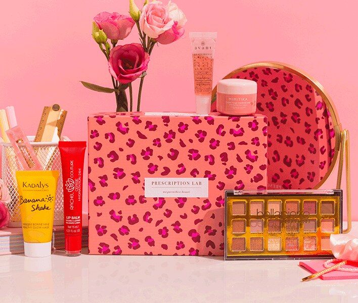 Box Prescription Lab Ready to Go à motif léopard, entourée de sa palette de fards, de son baume à lèvres et de roses