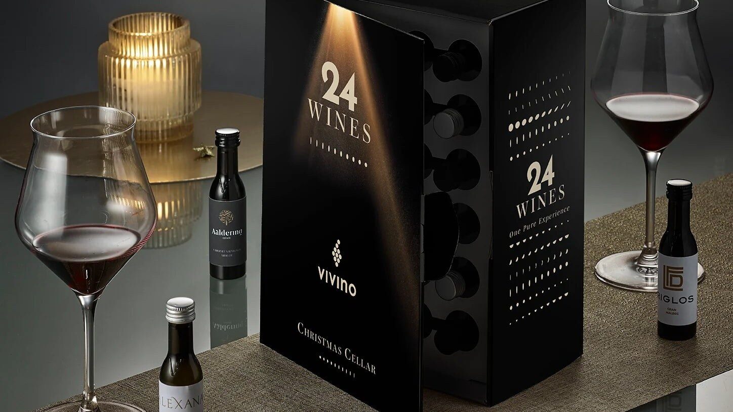 Le calendrier de l’Avent Vivino 2026 en forme de cave à vins, entouré de verres de vin rouge et de Vinottes