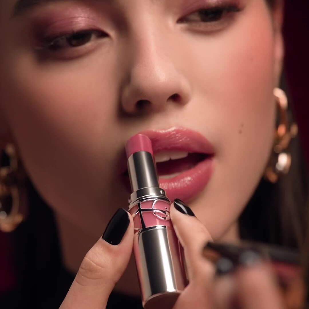 Une femme applique un rouge à lèvres rose YSL Beauty