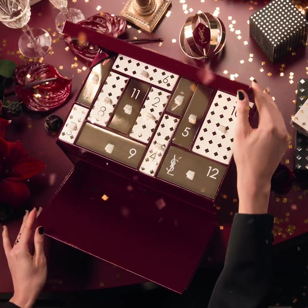 Le calendrier de l’Avent YSL Beauty 2026 ouvert sur une table de fête, avec ses cases numérotées blanches et dorées